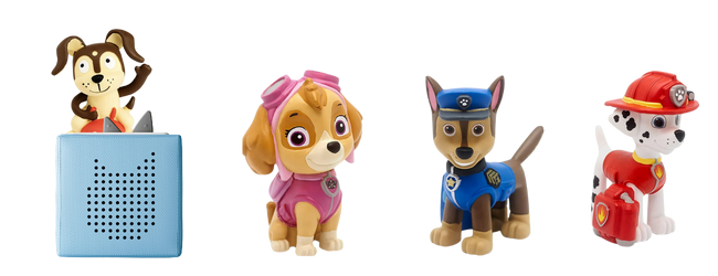 Blue speaker box with a puppy on top and 3 other dogs. One dressed in a pink sky suit, one dressed in a blue police officer uniform and one dressed in a red fireman uniform