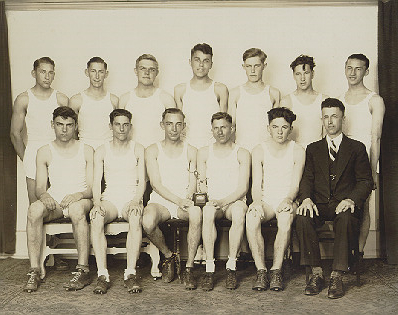 Athletes and their coach sit in two rows for the photo.